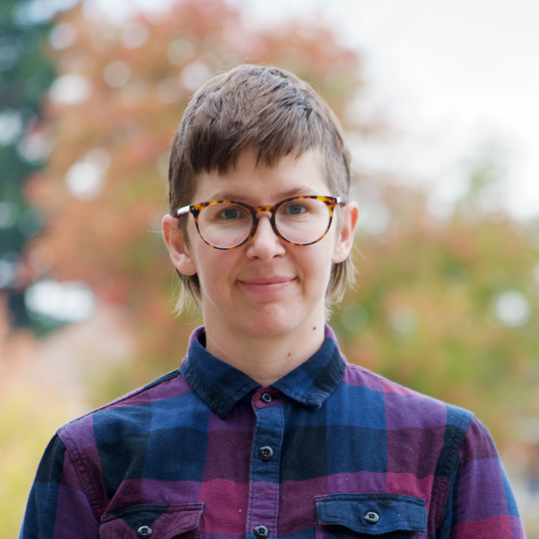 A person wearing glasses and a plaid shirt.